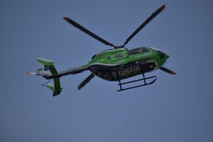 A green helicopter in the sky, labelled Life Flight.