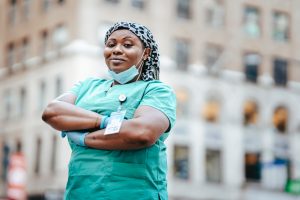 An RN poses proudly in front of her hospital.