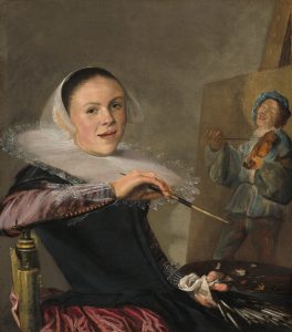 A painting of a woman who has paused in the act of painting to turn and look at the viewer. The taupe background sets off her dark hair, white headdress and wide, white ruff. She leans back against her chair, paintbrush in her right hand. In her left hand, she holds her palette, black against the black of her bodice. Her garnet-coloured dress sleeves are silk, and her cuffs are white lace. Her expression is open; she appears on the verge of speaking. On the easel, her work is of a fiddler dressed in blue tunic and hat.