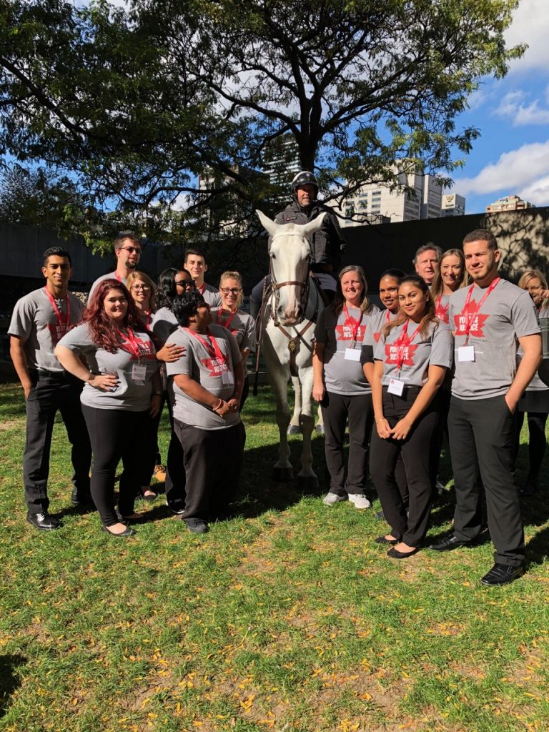 Group of students standing with a police officer on a horse.