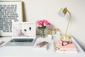 Decorative image of a desk with a laptop and pair of glasses