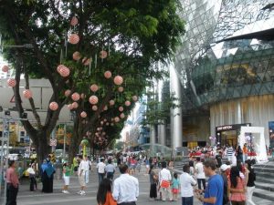 A busy pedestrian zone with people milling around the different outdoor spaces in the shopping district