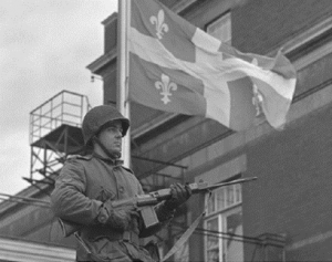 Un soldat près d'une drapeau du Québec