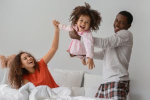 Une mère et un père tenant une petite fille en l'air
