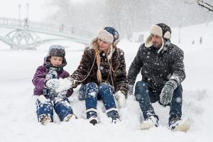 Une mère, une père et un fils dans la neige