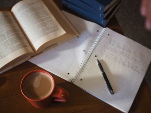 Open notebook with textbook and pen.