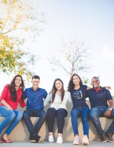 A group of people sitting on bench near trees during daytime.