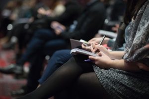 People sitting in rows taking notes.