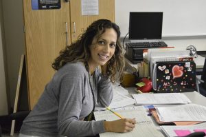 Woman stilling at the desk marking papers.