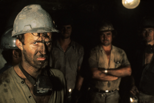 Several men posing in hardhats, mining gear