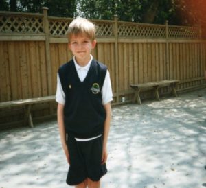 A photograph of a young boy wearing a school uniform.