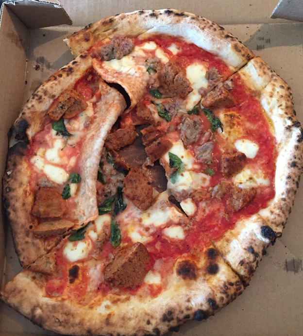 Squished pizza in a delivery box.
