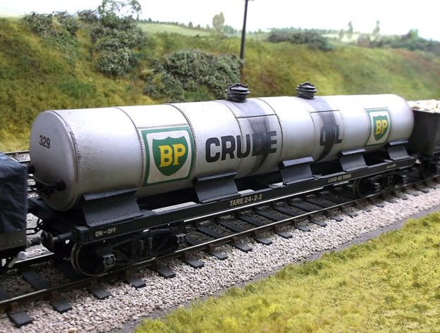 BP crude oil tanker train stopped on rail tracks beside a grassy hill