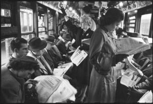 Black & whit image of people on the subway reading newspapers. 1946.