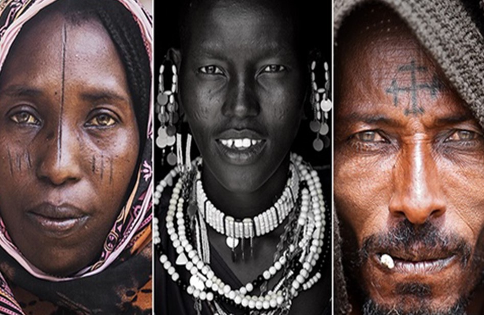 Three dark skinned faces with tribal markings and jewelry