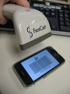 Handheld scanner scanning barcode from mobile phone.