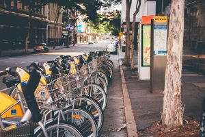 A group of bikes lined up beside each other at the side of a road.