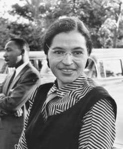 black and white portrait of a young Rosa Parks (Dr. Martin Luther King Jr. appears in the backgroun)