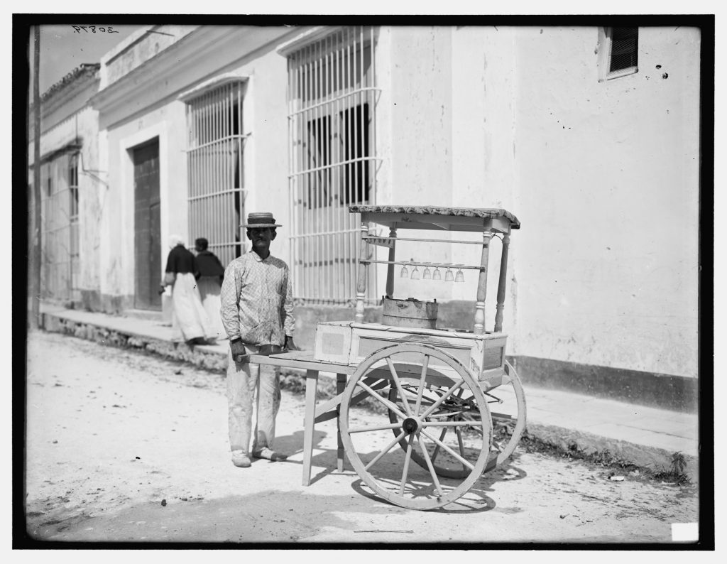 archival photo of a man and an ice cream hand cart in Havana Cuba
