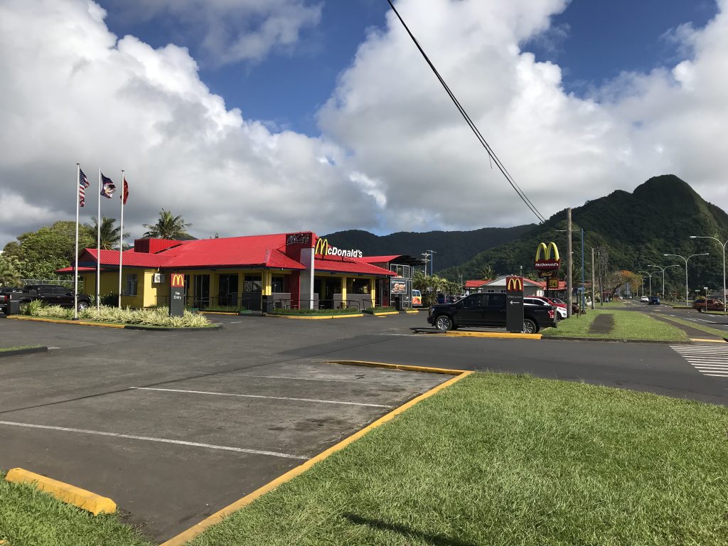 a McDonald&#039;s restaurant with parking lot in the foreground