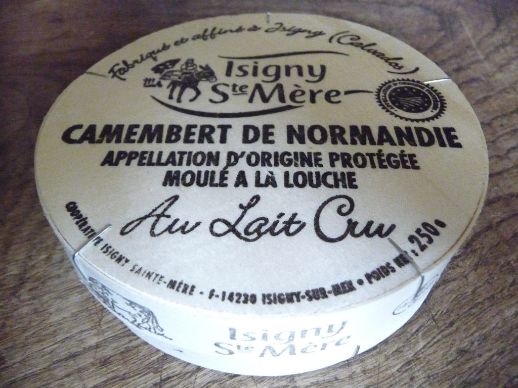 a wheel of camembert in its packaging with geographic indication markings on top