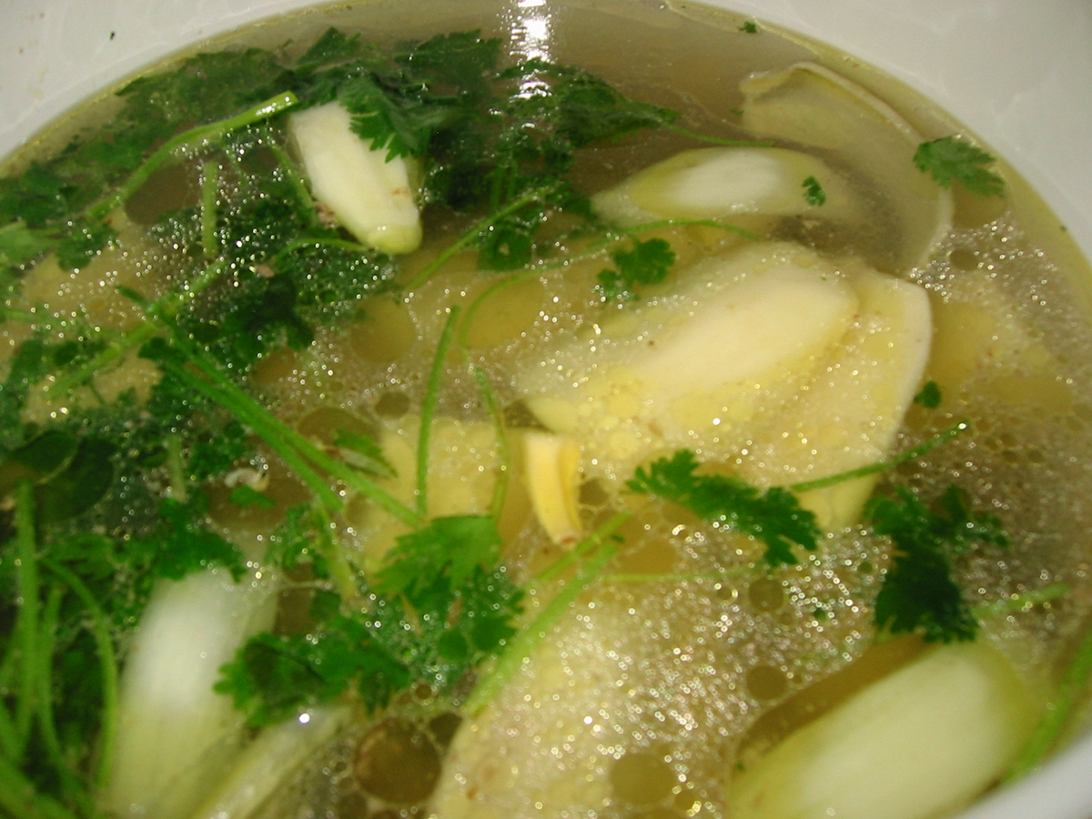 close up of a bowl of broth with vegetables