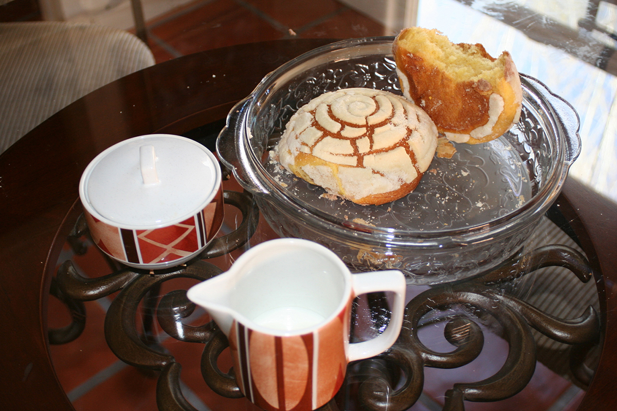 a dish with two pieces of pan dulce (sweet rolls) and a coffee service