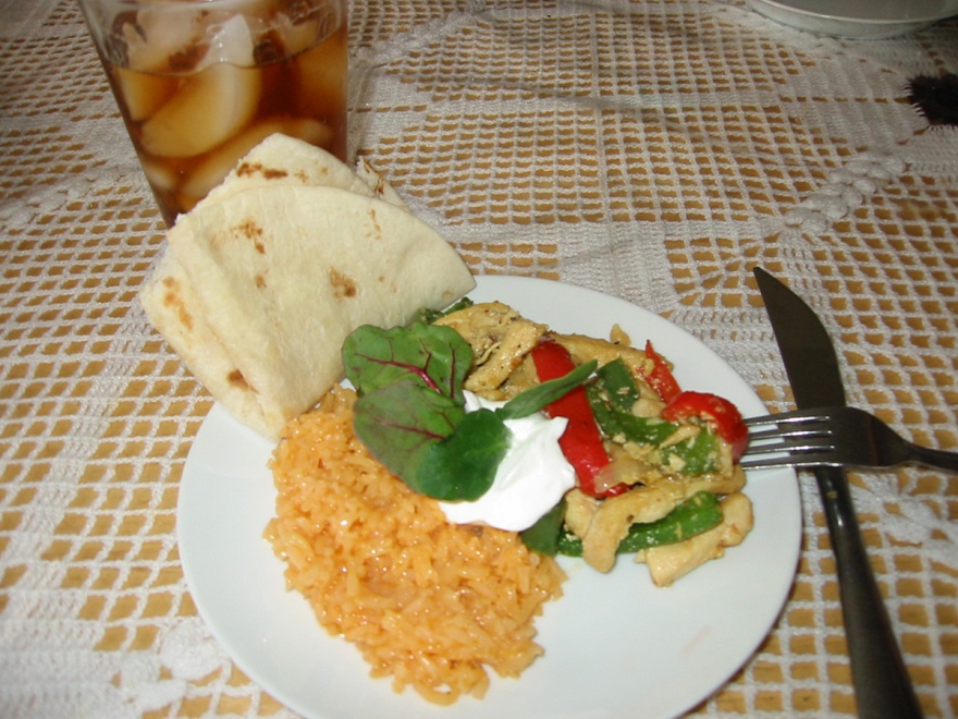 a plate of food with tortillas and rice, vegetables, and meat