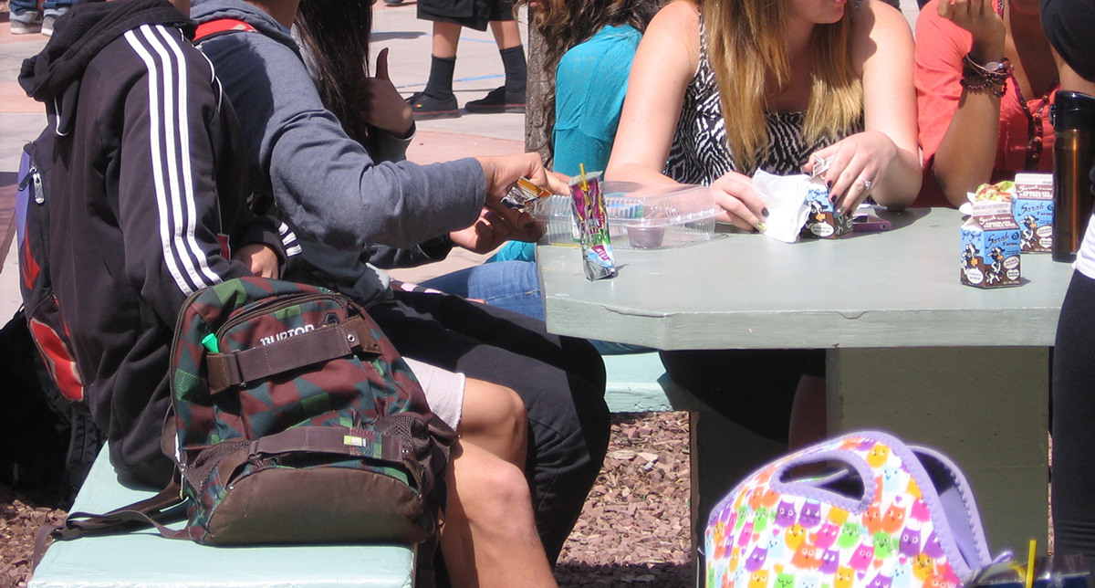 people sitting at table outdoors eating snacks