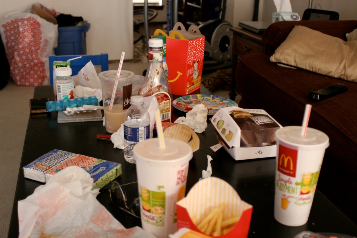 a table strewn with the leftovers and packaging of a fast food meal