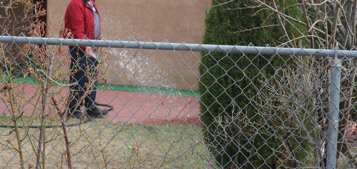 a person standing in the distance behind a low metal fence