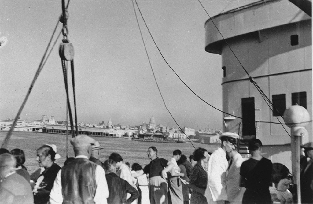 Black and white image of people standing aboard a large ship
