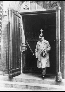 The photograph of Hitler leaving a church with a hat in his hand and a Cross over his head.