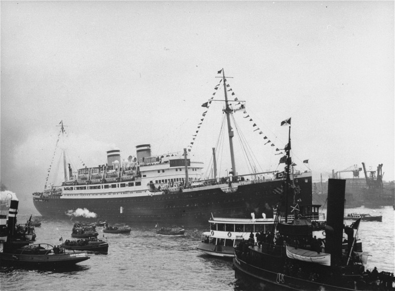 The starboard of MS St. Louis with several smaller ships in the foreground.