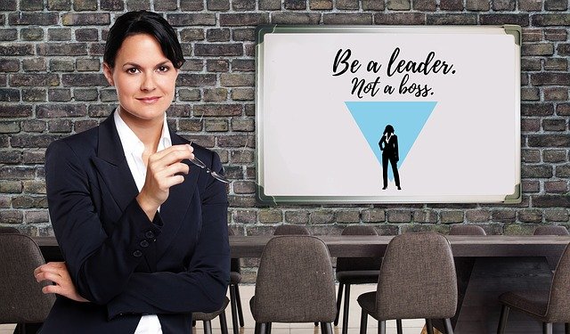 Women with sign behind her saying “Be a leader Not a boss”