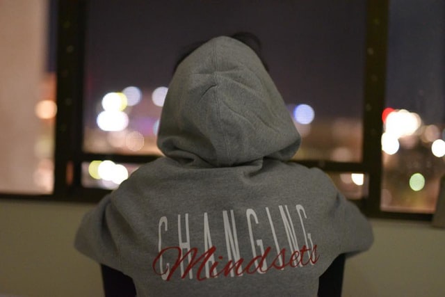 Back of a person in a hoodie that reads “changing mindsets”