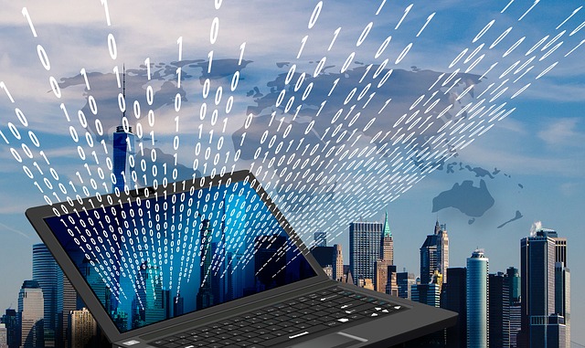 Skyline with open laptop with binary code emerging (data exchange)