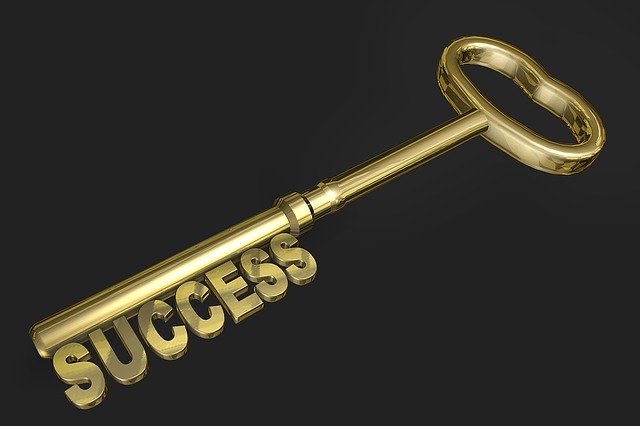 Gold key with the word “success” on it