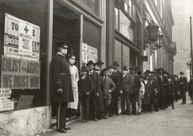 People waiting in a lineup outside a building, wearing masks in San Francisco during the Spanish Flu in 1918