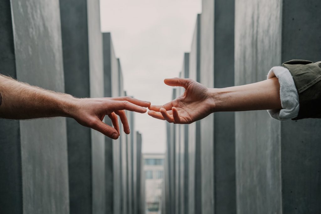a human hand connecting with another at the Jewish Memorial in Berlin
