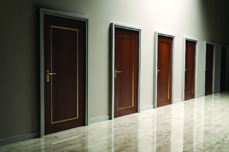 This image shows a row of six doors along the wall of an empty room.