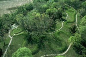 An aerial shot of raised earth covered in grass in the shape of a winding snake.