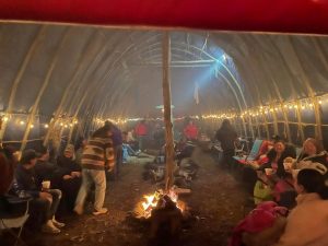 Anishnaabe Thunderbird Sundance. Image of people having fires under the arc