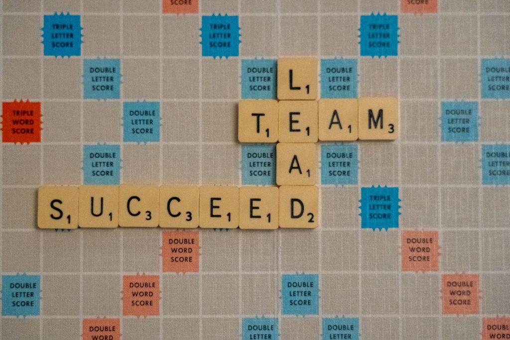 Scrabble game board with words: Lead, Team and Succeed
