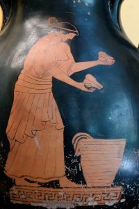 A street vendor offering fruits and pastries stacked in a great basket. Side A of an Attic red-figure pelike.