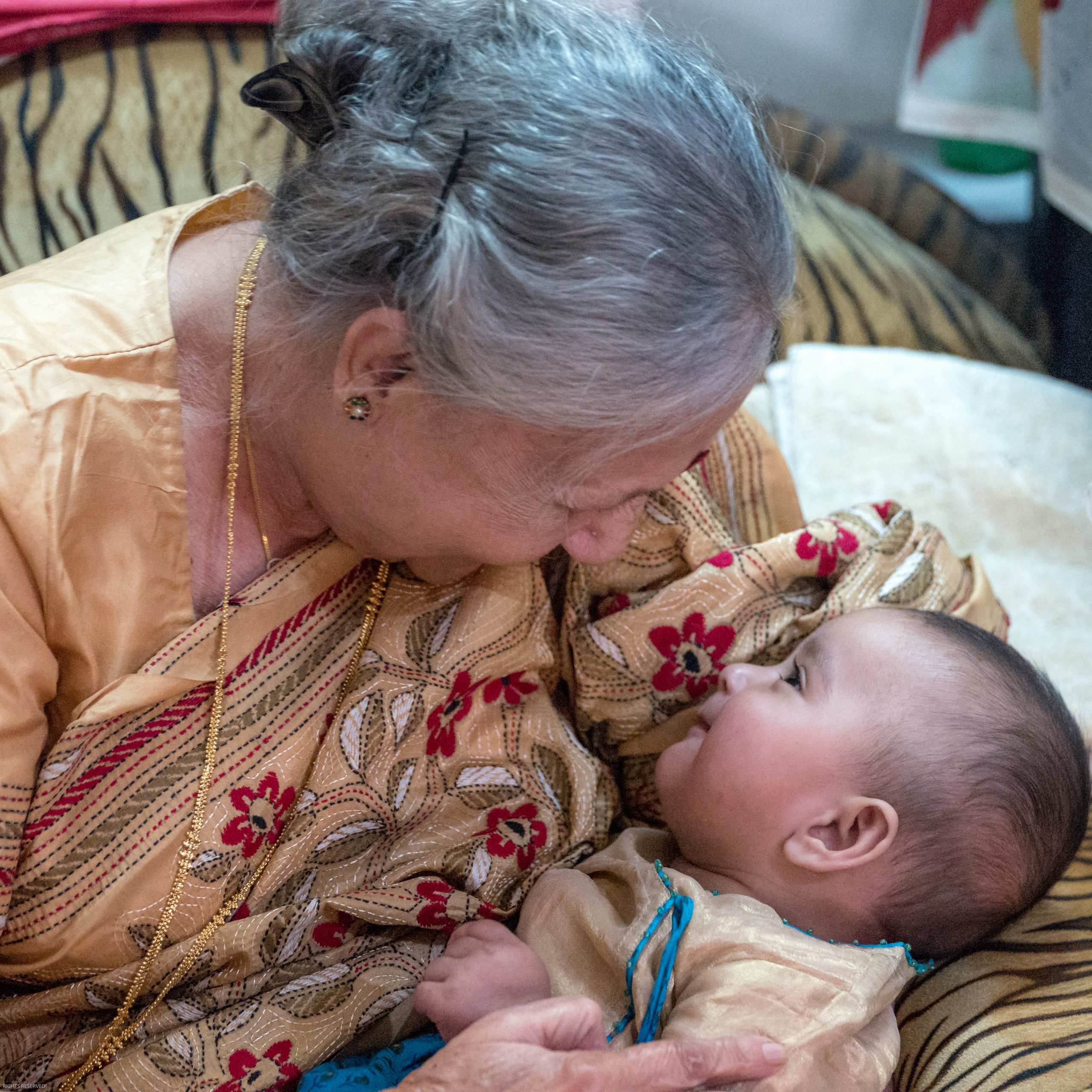 Photo of grandmother cradling grandchild.