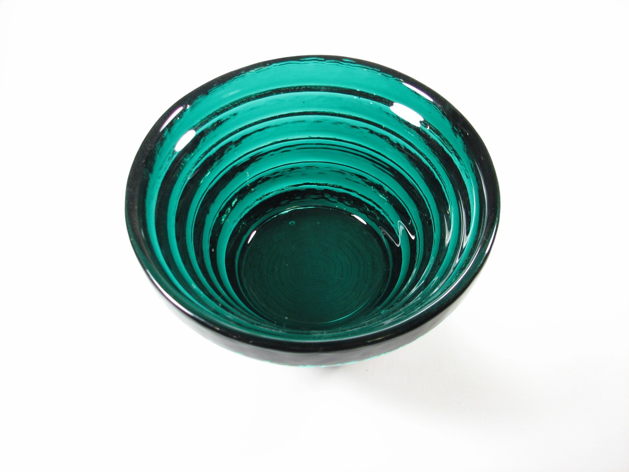 Photo of a bowl which has ridges around it at different heights. Its interior is not smooth, but ridged. The ridges are parallel to each other at different heights.