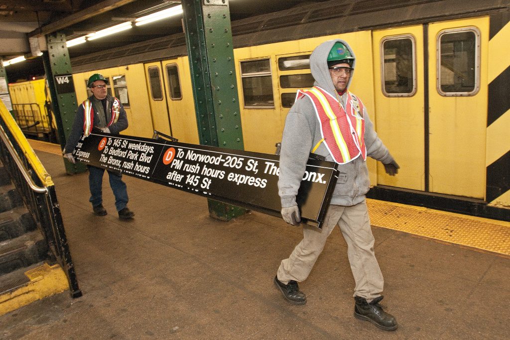 New York Metro workers carrying a sign