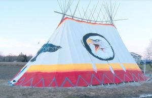 Tipi with symbols painted on sides including thunderbird and eagle
