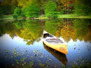 Empty yellow canoe on a calm lake
